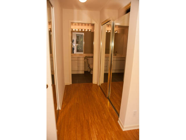 Bright hallway with hardwood floors and a view of the bathroom ahead. - 308 - 1327 East Keith Road, North Vancouver