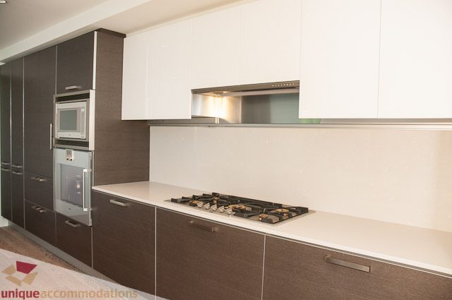 Bright kitchen with modern white cabinets, gas stove, and stainless steel appliances. - 302 - 1409 W Pender, Vancouver Downtown
