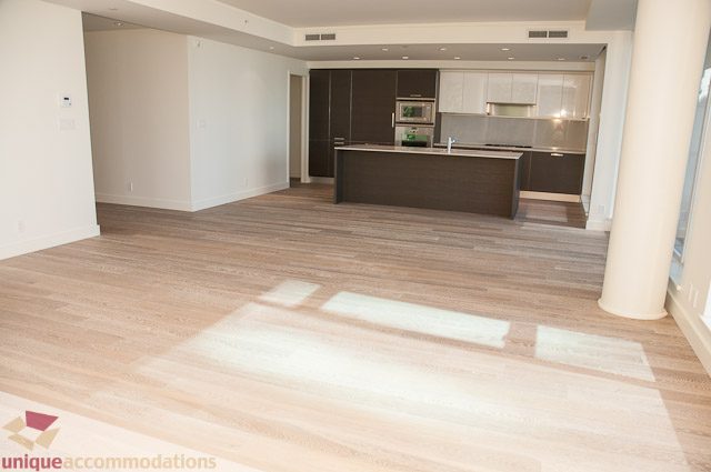 Bright open-concept living area with hardwood floors and modern kitchen island. - 302 - 1409 W Pender, Vancouver Downtown
