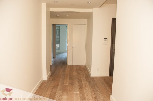 Bright hallway with hardwood floors and white walls leading to a den area. - 302 - 1409 W Pender, Vancouver Downtown