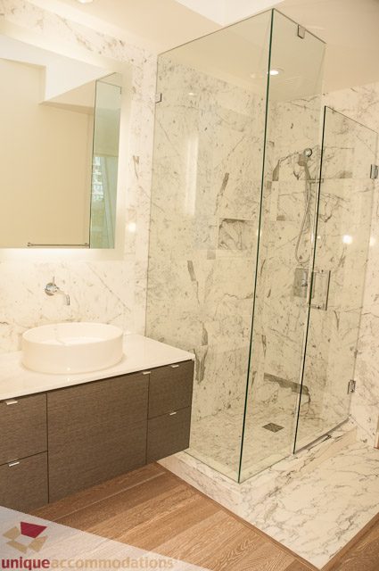 Furnished bathroom with marble countertops, glass shower, and hardwood floors. - 302 - 1409 W Pender, Vancouver Downtown