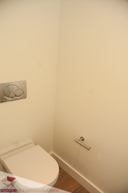 Bathroom with modern toilet and wall-mounted flush plate. - 302 - 1409 W Pender, Vancouver Downtown