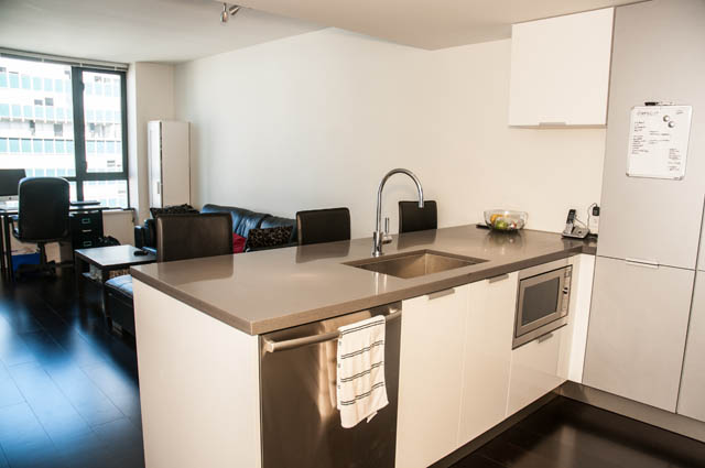 Bright kitchen with modern countertops and hardwood floors, featuring a city view. - 1504 - 788 Richards, Vancouver Downtown