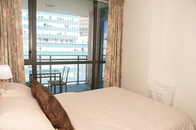 Bright bedroom with city view and floral curtains. - 1504 - 788 Richards, Vancouver Downtown