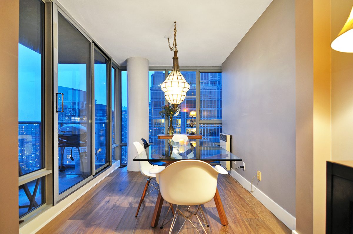 Furnished dining area with hardwood floors, city view, and modern chandelier. - 2702 - 930 Cambie Street, Vancouver Downtown