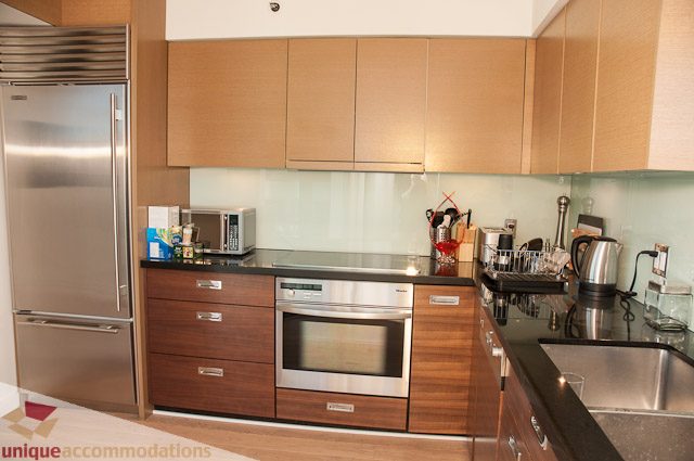 Bright kitchen with modern appliances, wooden cabinets, and a stainless steel fridge. - 604-1000 Beach Avenue, Vancouver Downtown
