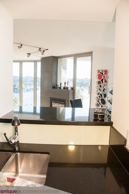 Modern kitchen with sleek black countertops and a city view. - 604-1000 Beach Avenue, Vancouver Downtown