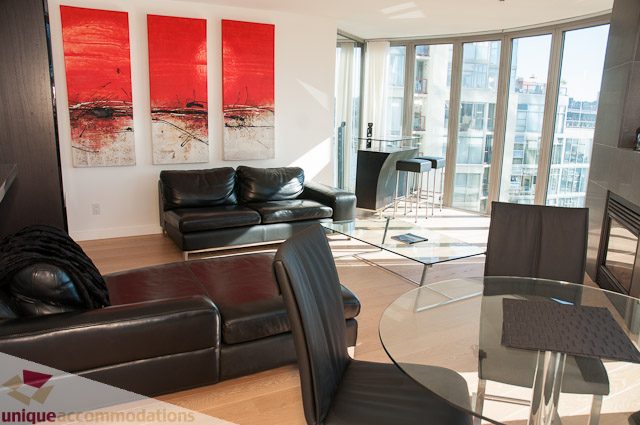 Spacious living room with modern furniture, large windows, and a city view. - 604-1000 Beach Avenue, Vancouver Downtown