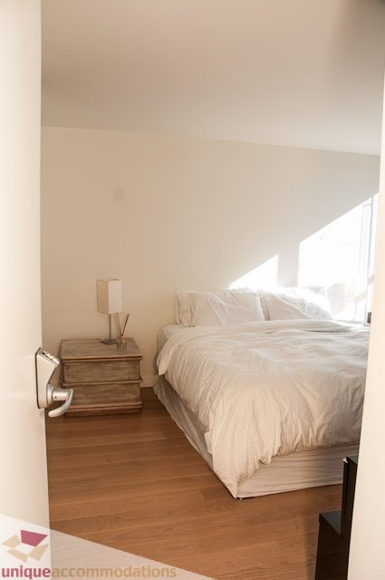 Bright bedroom with wooden floors and a cozy bed setup. - 604-1000 Beach Avenue, Vancouver Downtown