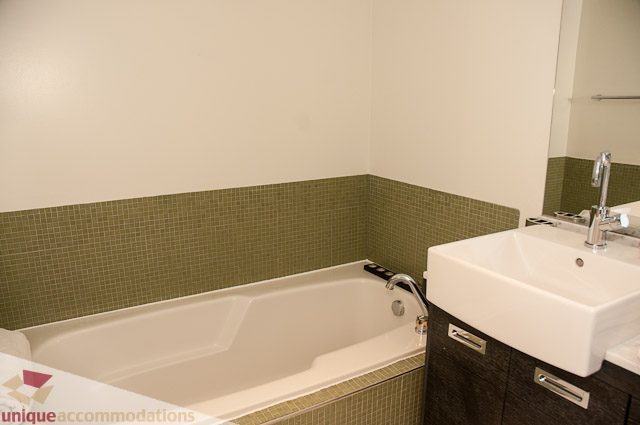 Modern bathroom with white sink and green mosaic tile backsplash. - 604-1000 Beach Avenue, Vancouver Downtown