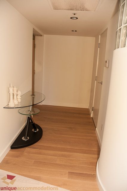 Bright hallway with wooden floors and glass table with chess pieces. - 604-1000 Beach Avenue, Vancouver Downtown