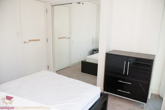 Furnished bedroom with white walls, black furniture, and a bed. - 604-1000 Beach Avenue, Vancouver Downtown
