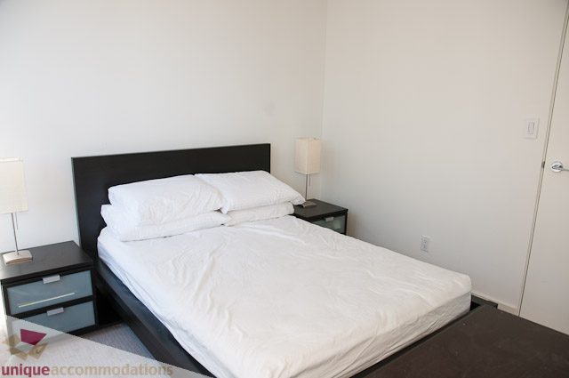 Spacious bedroom with neatly made beds and bedside lamps. - 604-1000 Beach Avenue, Vancouver Downtown