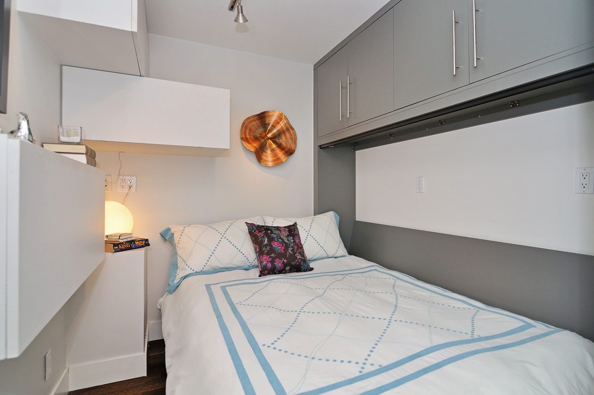 Furnished 1-bedroom + den with modern decor, white cabinets, and a cozy bed setup. - PH5- 869 Beatty St., Vancouver Downtown