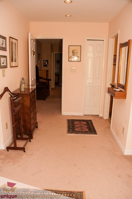 Living room with a small rug, wooden furniture, and framed artwork on the walls. - 4559 W. 3rd Ave, Vancouver West Side