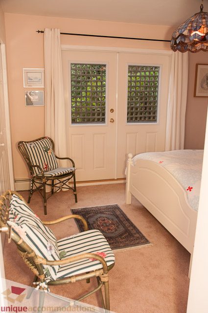 Bright bedroom with striped chairs and a bed, natural light from windows. - 4559 W. 3rd Ave, Vancouver West Side