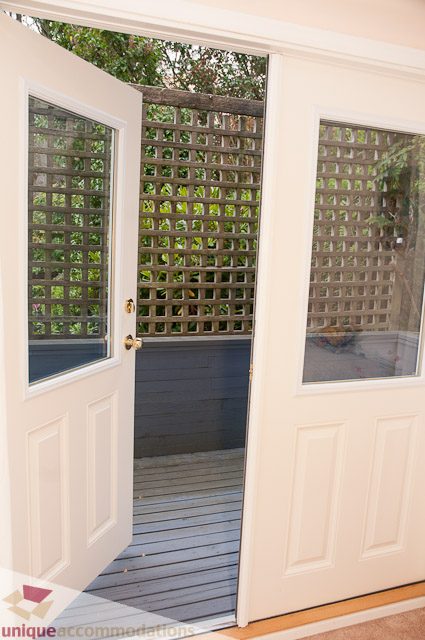 Entryway with wooden lattice and sliding glass doors leading to a deck. - 4559 W. 3rd Ave, Vancouver West Side