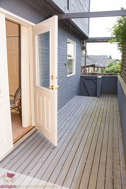 Bright deck with wooden flooring and a sliding glass door leading to the house. - 4559 W. 3rd Ave, Vancouver West Side
