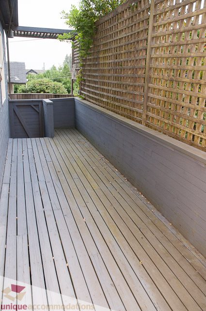 Spacious deck with wooden flooring and lattice privacy wall. - 4559 W. 3rd Ave, Vancouver West Side
