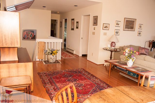 Furnished living room with hardwood floors, patterned rug, and modern decor. - 4559 W. 3rd Ave, Vancouver West Side