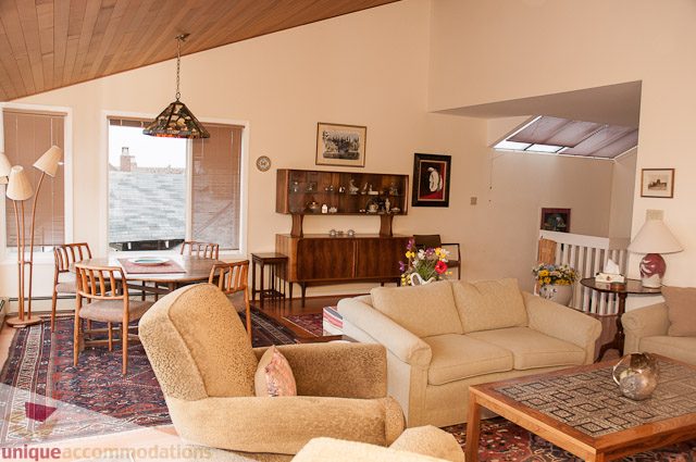 Spacious living room with large windows, hardwood floors, and a cozy sofa. - 4559 W. 3rd Ave, Vancouver West Side