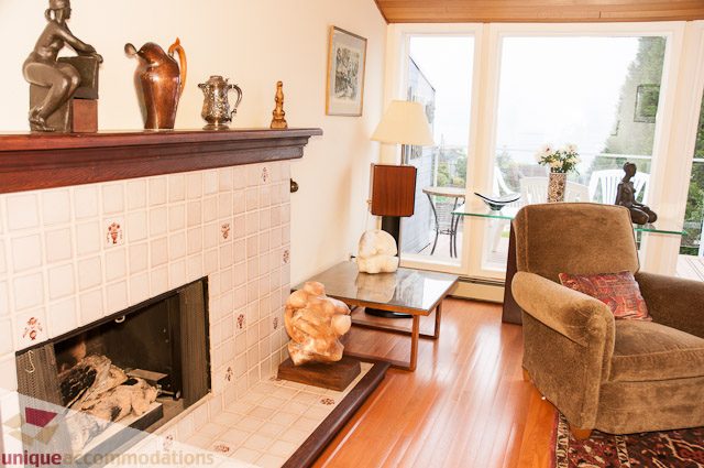 Furnished living room with a cozy fireplace, modern furniture, and large windows. - 4559 W. 3rd Ave, Vancouver West Side