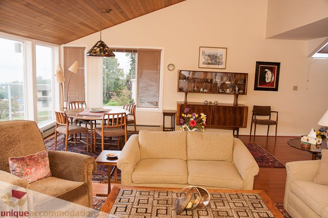 Spacious living room with hardwood floors, large windows, and modern decor. - 4559 W. 3rd Ave, Vancouver West Side
