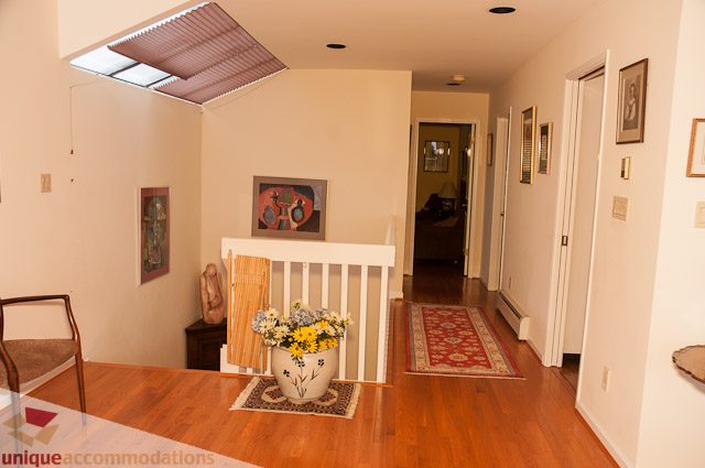 Furnished living room with hardwood floors, skylight, and artwork. - 4559 W. 3rd Ave, Vancouver West Side