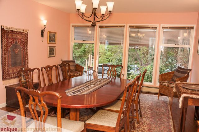 Furnished dining room with large windows, wooden chairs, and a chandelier. - 4559 W. 3rd Ave, Vancouver West Side
