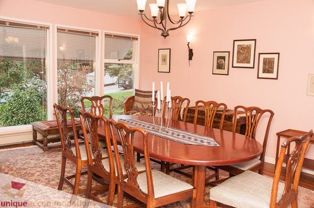 Formal dining room with wooden furniture and large windows. - 4559 W. 3rd Ave, Vancouver West Side
