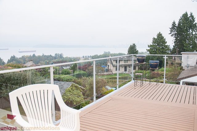 Furnished balcony with wooden deck, city view, and modern railings. - 4559 W. 3rd Ave, Vancouver West Side
