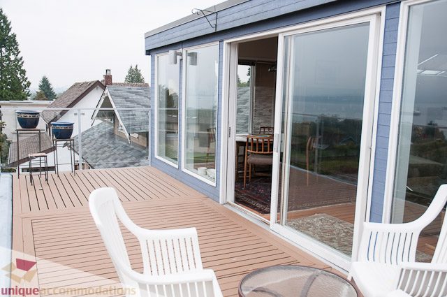 Furnished patio with glass doors, wooden deck, and city view. - 4559 W. 3rd Ave, Vancouver West Side
