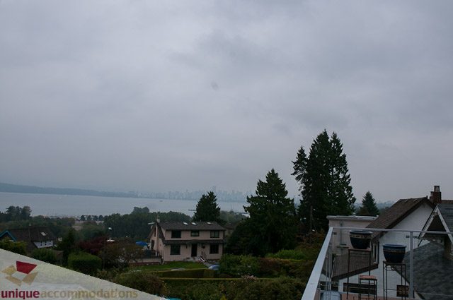 Bright living room with city view and lush greenery. - 4559 W. 3rd Ave, Vancouver West Side