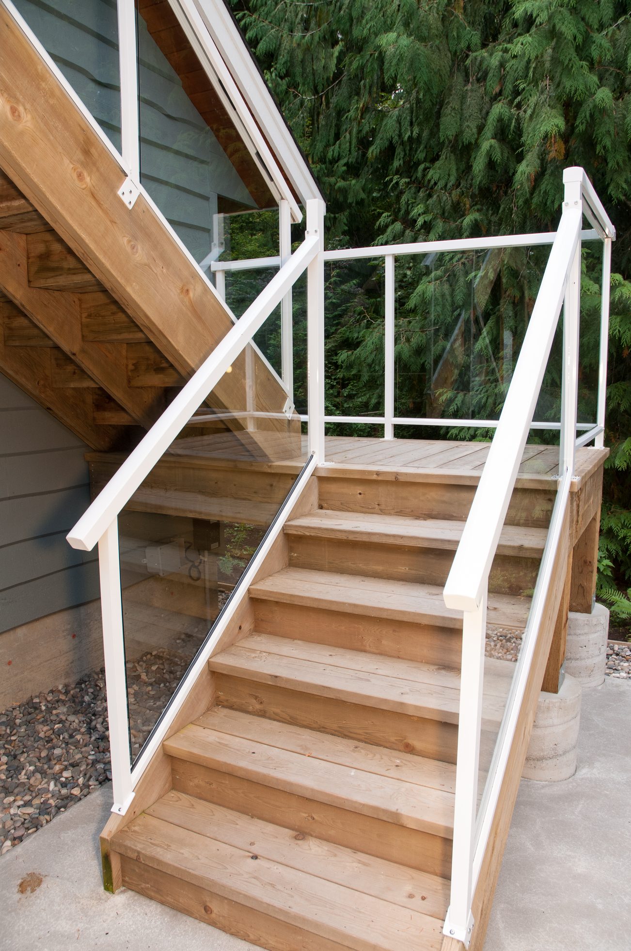 Furnished suite with wooden staircase and glass railings. - 2602 Cactus Court, North Vancouver