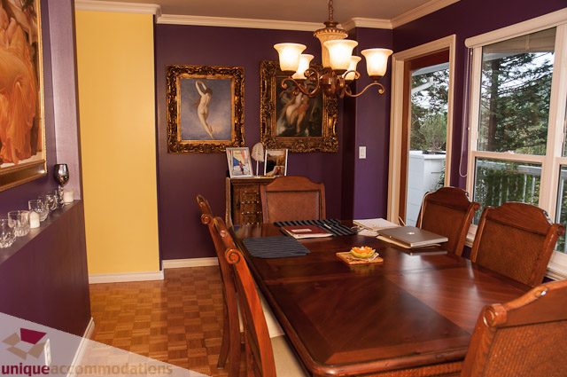 Elegant dining room with purple walls, wooden furniture, and framed artwork. - 1650 Riverside Drive, North Vancouver