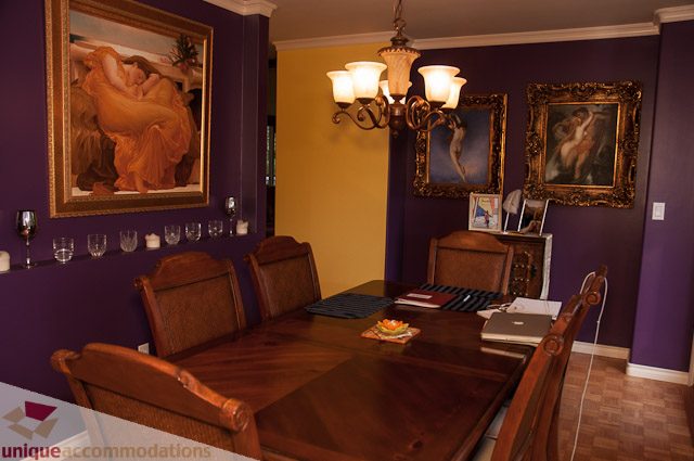 Dining room with purple walls, wooden furniture, and framed artwork. - 1650 Riverside Drive, North Vancouver