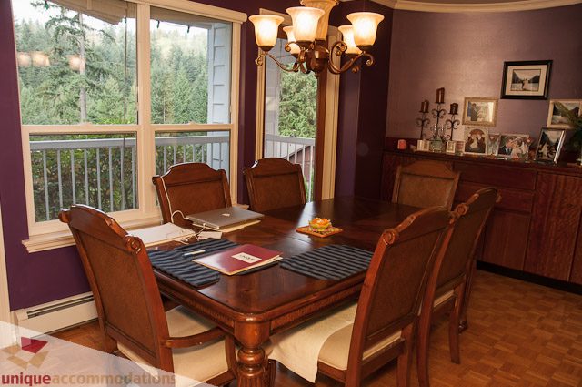 Formal dining room with wooden furniture, hardwood floors, and a view of the outdoors. - 1650 Riverside Drive, North Vancouver