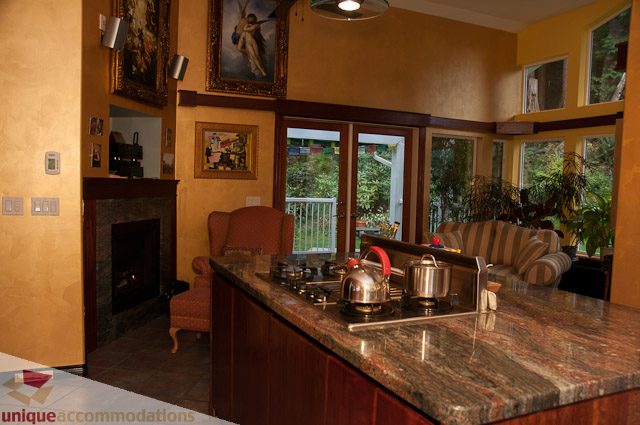 Spacious living room with large windows, granite countertops, and a cozy fireplace. - 1650 Riverside Drive, North Vancouver