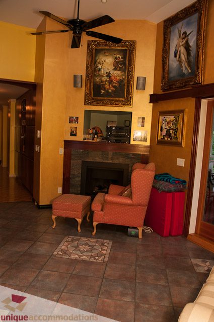 Furnished living room with fireplace, framed artwork, and tiled floor. - 1650 Riverside Drive, North Vancouver