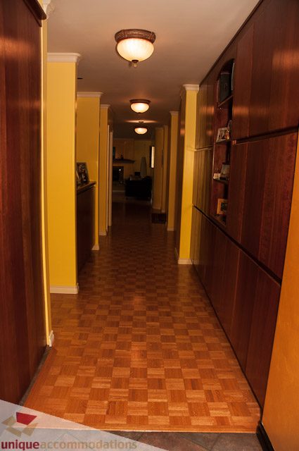 Furnished hallway with wooden floors and built-in cabinets. - 1650 Riverside Drive, North Vancouver
