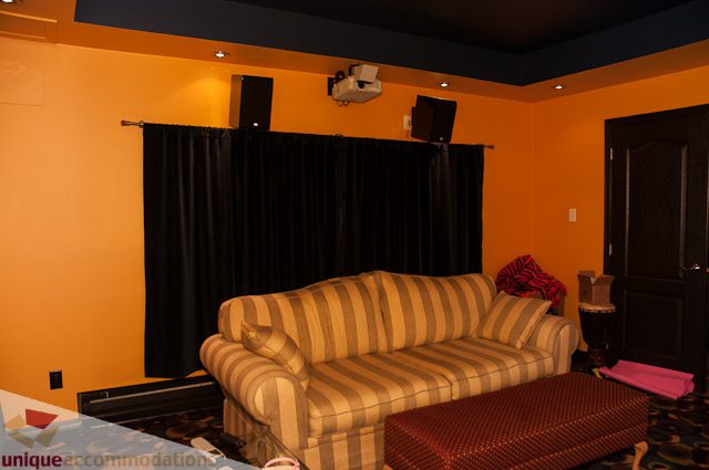 Home theater with striped recliners and black curtains. - 1650 Riverside Drive, North Vancouver