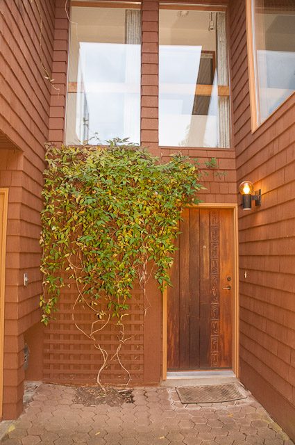 Cozy entryway with wooden door and ivy climbing wall. - 2919 Mathers Ave, West Vancouver