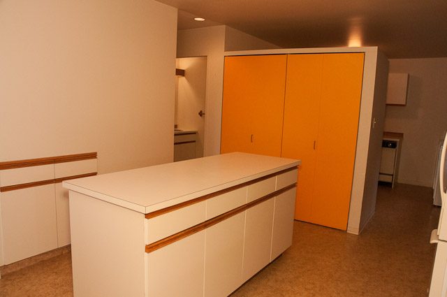Bright kitchen with white cabinetry and orange accents, modern design. - 2919 Mathers Ave, West Vancouver