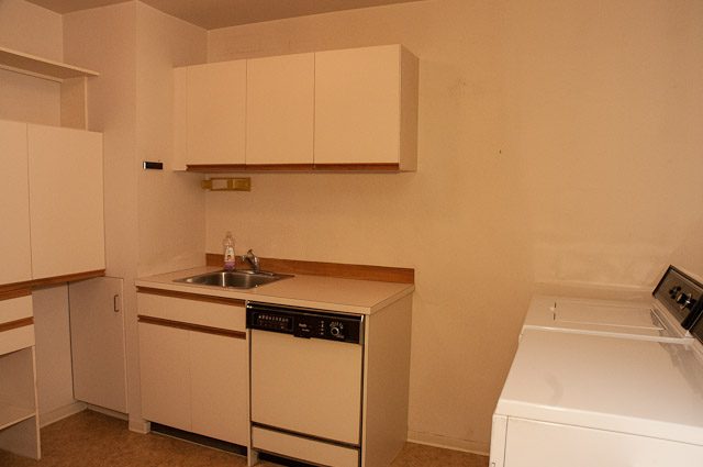 Bright kitchen with light-colored cabinets and a sink, minimalistic design. - 2919 Mathers Ave, West Vancouver