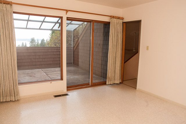 Bright living room with terrazzo floors and large windows offering a city view. - 2919 Mathers Ave, West Vancouver