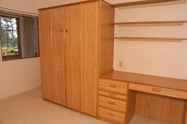 Bright bedroom with wooden furniture and a window view. - 2919 Mathers Ave, West Vancouver