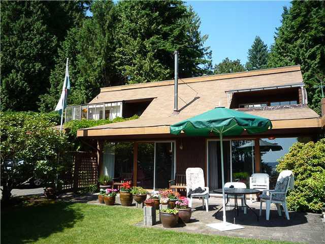 Furnished patio with outdoor seating, potted plants, and a view of trees. - 2919 Mathers Ave, West Vancouver