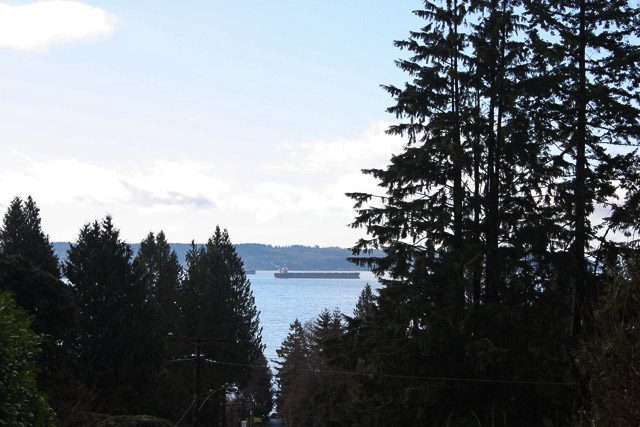 Spacious living room with a stunning city view and evergreen trees. - 2919 Mathers Ave, West Vancouver