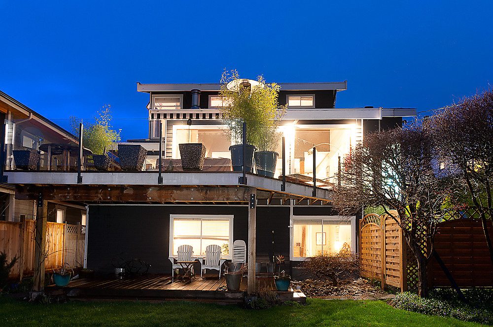 Furnished living room with cozy lighting and outdoor deck access. - 1119 Keith Road, West Vancouver