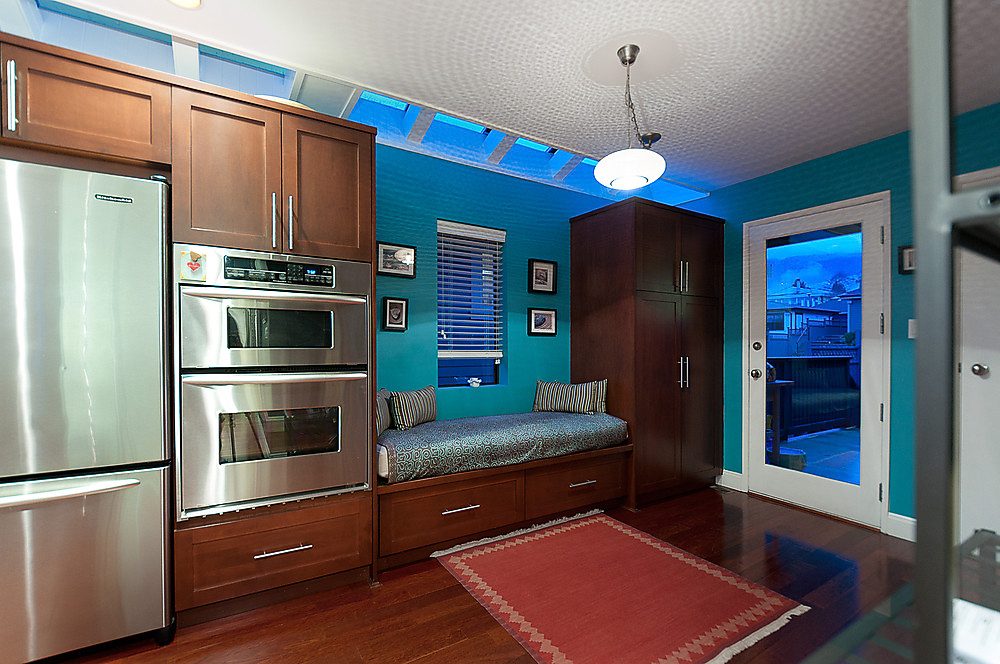 Bright kitchen with stainless steel appliances, hardwood floors, and a city view. - 1119 Keith Road, West Vancouver
